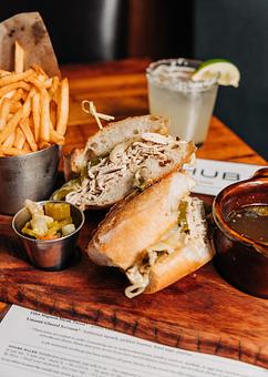 Product: slow roasted chicken breast is sliced and served on a baguette with melted provolone and sweet peppers. served with au jus for dipping, giardinera and french fries - Hub 51 in River North - Chicago, IL American Restaurants