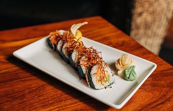 Product: nori seaweed wrapped around sushi rice, avocado, cucumber and fresh salmon, topped with fried ginger root. sliced into six pieces and served with soy sauce, pickled ginger and wasabi - Hub 51 in River North - Chicago, IL American Restaurants
