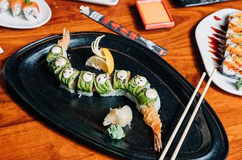Product: nori seaweed wrapped with sushi rice, fresno peppers, scallions and tempura fried shrimp. topped with thinly sliced avocado, creamy yuzu mayo and a sprinkle of sesame seeds. sliced into eight pieces and served with soy sauce, pickled ginger and wasabi - Hub 51 in River North - Chicago, IL American Restaurants