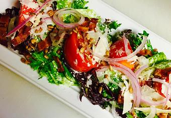 Product: Mixed greeens and romaine tossed in a buttermilk dressing with heirloom tomatoes, bacon, red onion, sunflower seeds, and shaved Pecorino Romano. - JJ's Restaurant in Kansas City, MO French Restaurants