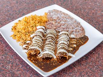 Product: (3) Rolled Corn Tortillas stuffed with Pulled Chicken and doused in an authentic Molé made of a closely guarded Old World combination of Dried Peppers & Spices, served with (2) Sides - La Lupita Tacos Mexicanos in Olneyville - Providence, RI Mexican Restaurants