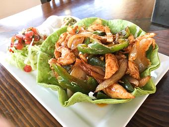 Product: Organic chicken or beef sautéed with green peppers and onions atop fresh lettuce greens in a crispy flour tortilla shell. Served with sour cream, guacamole and salsa Mexicana. - Las Brisas Mexican Restaurant in Edmonds, WA Steak House Restaurants