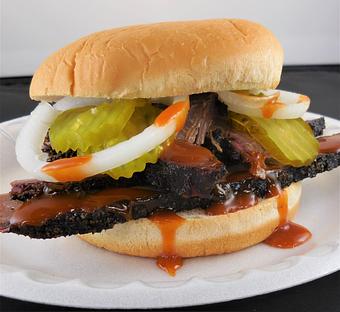Product: Slow smoked brisket sandwich, with pickles, onions and Meyers Original bbq sauce. - Meyer's Elgin Smokehouse in Elgin, TX Barbecue Restaurants