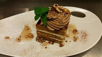 Product: Pumpkin spice cake layered with cream cheese and topped with buttercream icing, sea salt, and toasted nuts. - Michael Anthony's at the Inn in Versailles, OH Restaurants/Food & Dining