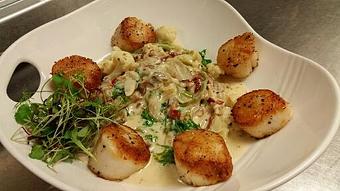 Product: Fresh spinach linguine with sauteed shallots, cauliflower, crispy bacon, sundried tomatoes, and fresh kale in a white wine cream sauce, topped with pan seared scallops. - Michael Anthony's at the Inn in Versailles, OH Restaurants/Food & Dining