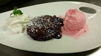 Product: Extra dark chocolate lava cake served warm with peppermint gelato. - Michael Anthony's at the Inn in Versailles, OH Restaurants/Food & Dining