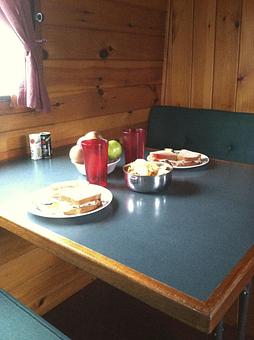 Product: This is the dinette on the Lockmaster 42', "Seneca".  The table drops down and gets covered with cushions for additional sleeping space in the galley. - Mid-Lakes Navigation Company in Skaneateles, NY Business Services