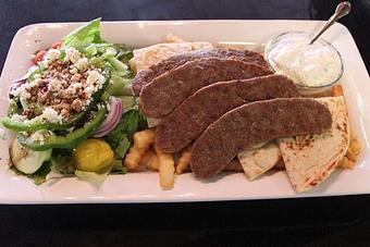 Product: The traditional spiced meat sliced and grilled. Served with warm pita bread, a side of Greek salad, French fries and tzatziki sauce. 16.95 - Nikolas Pizza in Newport, RI Pizza Restaurant