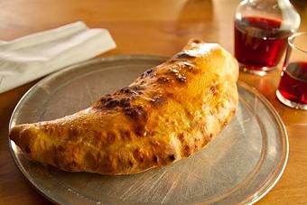 Product: Seasonally inspired menu with daily specials. Pictured: Calzone Carnivore. - Onespeed in Sacramento, CA Pizza Restaurant