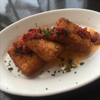 Product: A cold weather treat for the winter season! Hand-formed fritters filled with creamy béchamel, orzo pasta and roasted cauliflower drizzled with a cherrywood bacon and sun-dried tomato oil. - Paesano Restaurant & Wine Bar in Ann Arbor, MI Italian Restaurants