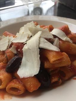 Product: A Sicilian classic. House-made rigatoni tossed with pan sautéed eggplant, pitted kalamata olives, crushed tomatoes, fresh basil leaves, and then topped with shavings of ricotta salata. - Paesano Restaurant & Wine Bar in Ann Arbor, MI Italian Restaurants