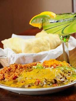 Product: Succulent green carne adovada baked in sweet corn masa with bits of vegetables, green chile and a touch of onion, set off with a liberal lacing of melted cheese and green chile. served with arroz. - Papa Felipe's in Albuquerque, NM Mexican Restaurants