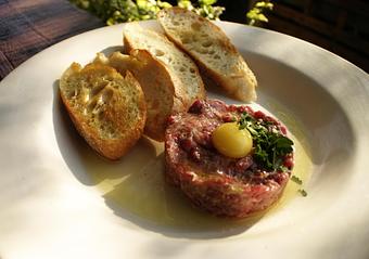 Product: Hand cut beef tossed w/ caper, shallot, mustard and fresh herbs topped with quail yolk. Served with crostini - PUBlic House in Old Town Temecula - Temecula, CA American Restaurants