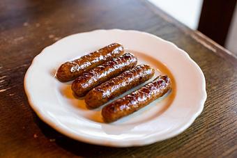 Product: four chicken sausage links served on a white plate - RJ Grunts in Lincoln Park - Chicago, IL American Restaurants