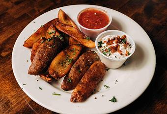 Product: sliced potato skins with chopped green onion on top served on a white plate - RJ Grunts in Lincoln Park - Chicago, IL American Restaurants