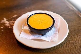 Product: a dish of merkts cheedar cheese in a black bowl on a white plate on a brown table - RJ Grunts in Lincoln Park - Chicago, IL American Restaurants
