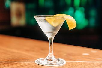 Product: A dirty gin martini in a chilled martini glass with a lemon peel garnish - RJ Grunts in Lincoln Park - Chicago, IL American Restaurants