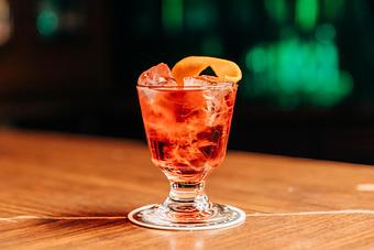 Product: a negroni cocktail poured over ice and garnished with an orange peel slice - RJ Grunts in Lincoln Park - Chicago, IL American Restaurants