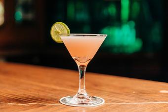 Product: a cosmopolitan in a martini glass with a sliced lime wheel garnish - RJ Grunts in Lincoln Park - Chicago, IL American Restaurants