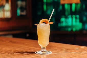 Product: A cup filled with an Amaretto Sour and ice, garnished with an orange slice and a cherry, with a straw - RJ Grunts in Lincoln Park - Chicago, IL American Restaurants