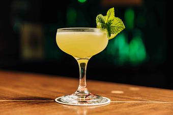 Product: A martini glass filled with a green cocktail, garnished with a mint leaf - RJ Grunts in Lincoln Park - Chicago, IL American Restaurants