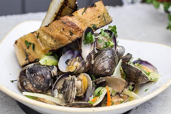 Product: Emerald Acres Manila Clams loaded with Mirepoix, Fennel, Butter and Grilled Bread - Salty's on Alki in Alki Beach, West Seattle - Seattle, WA American Restaurants