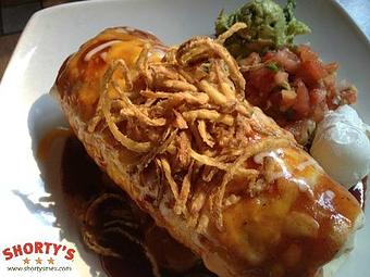 Product: An oversized flour tortilla is filled with slow roasted boneless Short Ribs, Jack Daniels BBQ sauce, caramelized onions, black beans, and Mexican rice, topped with more BBQ sauce, melted Cheddar Jack cheese, and frizzled onions. - Shorty's Mexican Roadhouse in Bedford, NH Mexican Restaurants