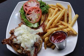 Product: Buttermilk Fried Chicken is infused with habanero Buffalo sauce, deep-fried, and served with Bacon, Pepper/Jack cheese, jalapeño mayo, lettuce, and tomato on a roll with French Fries. - Shorty's Mexican Roadhouse in Nashua, NH Mexican Restaurants