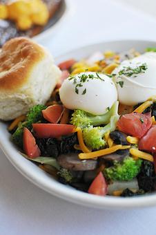 Product: The Veggie. A skillet of homefries, broccoli, mushrooms, spinach, tomatoes in a blanket of melted cheeses topped with two poached eggs. - Skillets - Collgny Plaza in Colginy Plaza Shopping Center - Hilton Head Island, SC American Restaurants