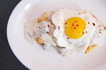 Product: house-smoked brisket gravy on our buttermilk biscuit topped with two sunny side up eggs - Southport Grocery & Cafe in Lakeview - Chicago, IL American Restaurants