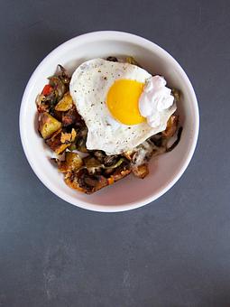 Product: roasted local potatoes, red onion, mushroom, peppers, white cheddar topped with organic fried eggs & chive-sour cream - Southport Grocery & Cafe in Lakeview - Chicago, IL American Restaurants