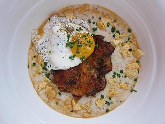 Product: cheesy hazzard-free farm corn grits, seared boneless chicken thigh, a sunny side up egg & house made ancho maple hot sauce - Southport Grocery & Cafe in Lakeview - Chicago, IL American Restaurants