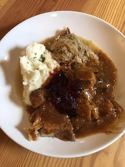 Product: Schweinebraten- Roasted Pork in Beer Sauce with Mashed Potatoes & Sauerkraut. topped with cranberry sauce - Speisekammer in Alameda, CA Bars & Grills