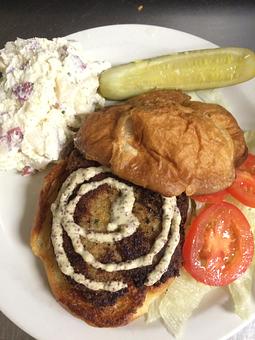Product: Crab cake sandwich topped with remoulade on a toasted croissant with lettuce and tomato - Sunflower Cafe in Charleston, SC American Restaurants Product: Crab cake sandwich topped with remoulade on a toasted croissant with lettuce and tomato - Sunflower Cafe in Charleston, SC American Restaurants