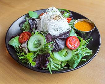 Product: a side of carrot-ginger dressing sets apart our house salad featuring mesclun greens, cucumber, Mighty Vine cherry tomatoes, spiralized daikon and fresh cracked pepper. - Sushi San - Reservations in River North - Chicago, IL Japanese Restaurants
