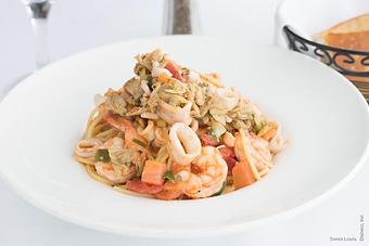 Product: Baby clams, calamari and prawns in a light Sicilian garlic and tomato sauce served on a bed of spaghetti. - Swiss Louis in San Francisco, CA Restaurants/Food & Dining