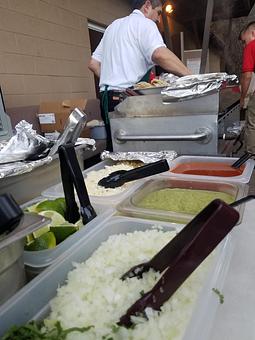 Product: Cilantro, onions, Cheese, Guacamole, Lime, Grilled onions(in the silver tin) waiting to be topped on tacos in Anderson Park at a wedding. - Taqueria Los Gordos in Redding, CA Mexican Restaurants