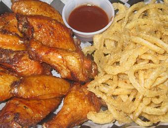 Product: A dozen of our famous Smoked Wings and a half-pound of our made-to-order Onion Straws! - The BBQ Shack in Paola, KS Barbecue Restaurants