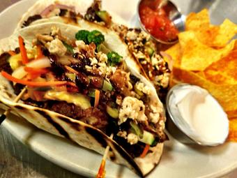 Product: Crispy chicked marinated in a blueberry, maple, bourbon sauce, veggie slaw, 3 Sheep's First Kiss IIPA beer cheese sauce, topped with bacon granola crunch. - The Brass Ring in Madison, WI Bars & Grills