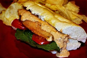 Product: U.S. Farm-raised Catfish fillet lightly fried then fully dressed on Gambino's New Orleans French Bread with our homemade comeback sauce! - The Crown Restaurant in Indianola, MS American Restaurants