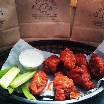 Product: Deep Fried Buffalo Wings also available in Chipotle, Mild, BBQ. Served with Celery Sticks and a side of Ranch or Blue Cheese - The Elephant Shack in Woodland, CA American Restaurants