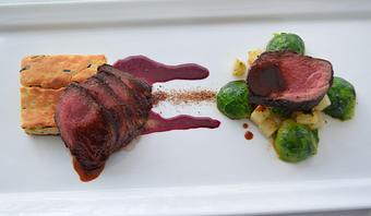 Product: Cervena Venison N.Y. Strip Loin,
Wild Rice Genoise, Thyme Glazed Celeriac and 
Brussels Sprouts, Huckleberry Sauce, Juniper - The Frog & The Peach in New Brunswick, NJ American Restaurants