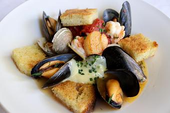 Product: Seasonally inspired menu with daily specials. Pictured: Fish & Shellfish Acqua Pazza with Today's Selection, Tomatoes, Chilies, Garlic, White Wine, Bruschetta & Aioli - The Waterboy in Sacramento, CA American Restaurants