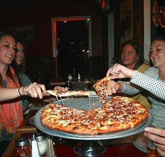 Product: Friends enjoying a Ranch BBQ Chicken Pizza at the Mission St. Location - Upper Crust Pizza & Pasta in Westside Santa Cruz - Santa Cruz, CA Pizza Restaurant