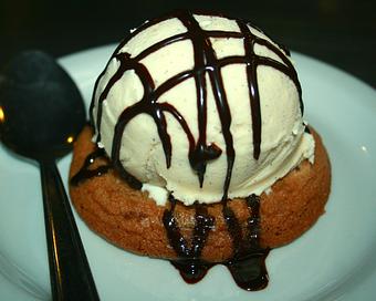 Product: Warm Pacific Cookie Company chocolate chip cookie with a scoop of Marianne's Vanilla  Ice Cream, drizzled with chocolate sauce - Upper Crust Pizza & Pasta in Westside Santa Cruz - Santa Cruz, CA Pizza Restaurant