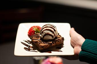 Product: House-baked walnut brownie with vanilla bean ice cream. - Midtown Cafe in Nashville, TN American Restaurants Product: House-baked walnut brownie with vanilla bean ice cream. - Midtown Cafe in Nashville, TN American Restaurants