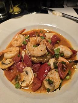 Product: Blackened shrimp tossed with bacon, mushrooms, tomatoes and scallions
served over stone ground smoked Gouda cheese grits. - Midtown Cafe in Nashville, TN American Restaurants Product: Blackened shrimp tossed with bacon, mushrooms, tomatoes and scallions
served over stone ground smoked Gouda cheese grits. - Midtown Cafe in Nashville, TN American Restaurants