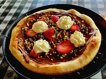 Product: Our baked dough topped with a layer of creamy Nutella, whipped cream, sliced strawberries and chopped Hazel nuts. - Nikolas Pizza in Newport, RI Pizza Restaurant