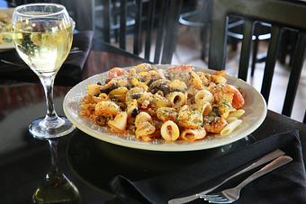 Product: Choose tender rings of calamari or shrimp or both sauteed with onions, hot peppers and sliced black olives in our spicy marinara sauce. Choice of pasta served with garlic bread. - Nikolas Pizza in Newport, RI Pizza Restaurant