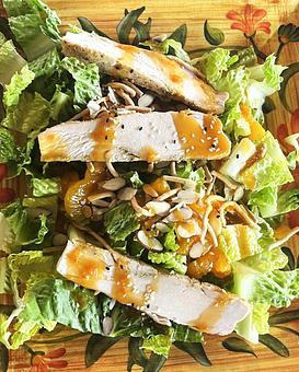 Product: Crisp romaine lettuce, mandarin oranges sesame seeds, oriental noodles, sliced almonds and sliced chicken breast. Topped with  sesame ginger dressing. - Nikolas Pizza in Newport, RI Pizza Restaurant